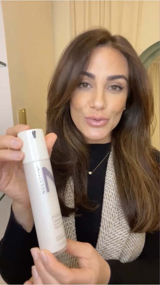 Video still — creator holding a Nulastin hair treatment bottle